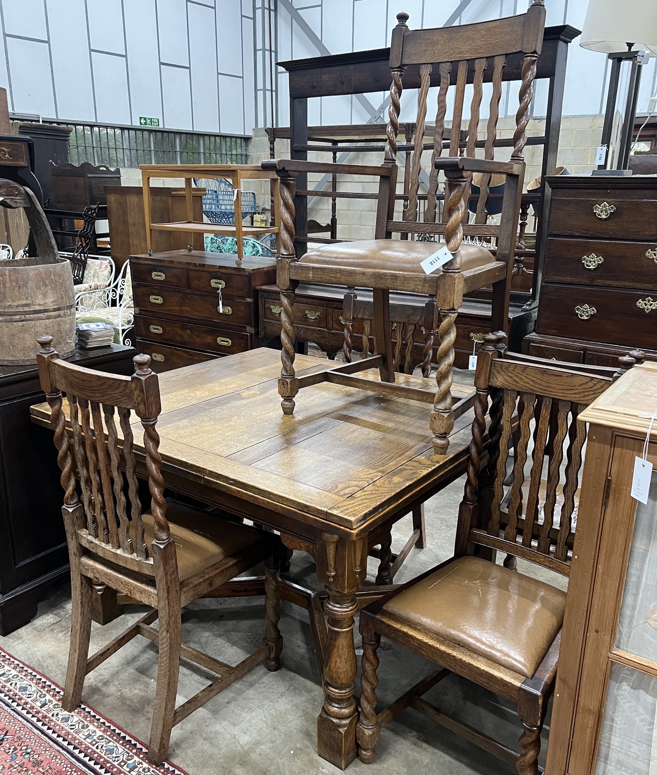 An early 20th century oak draw leaf dining table, width 120cm, depth 106cm, height 76cm together with five oak dining chairs, one with arms